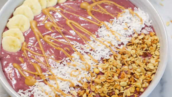 Overhead view of a smoothie bowl with various toppings in a white bowl