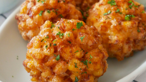 Close up shot of four Korean corn cheese balls on a white plate