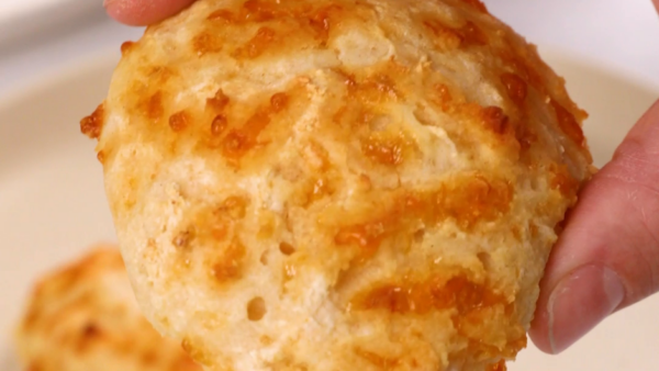 a hand holding a Three-Ingredient Cheesy Yogurt Drop Biscuits Recipe